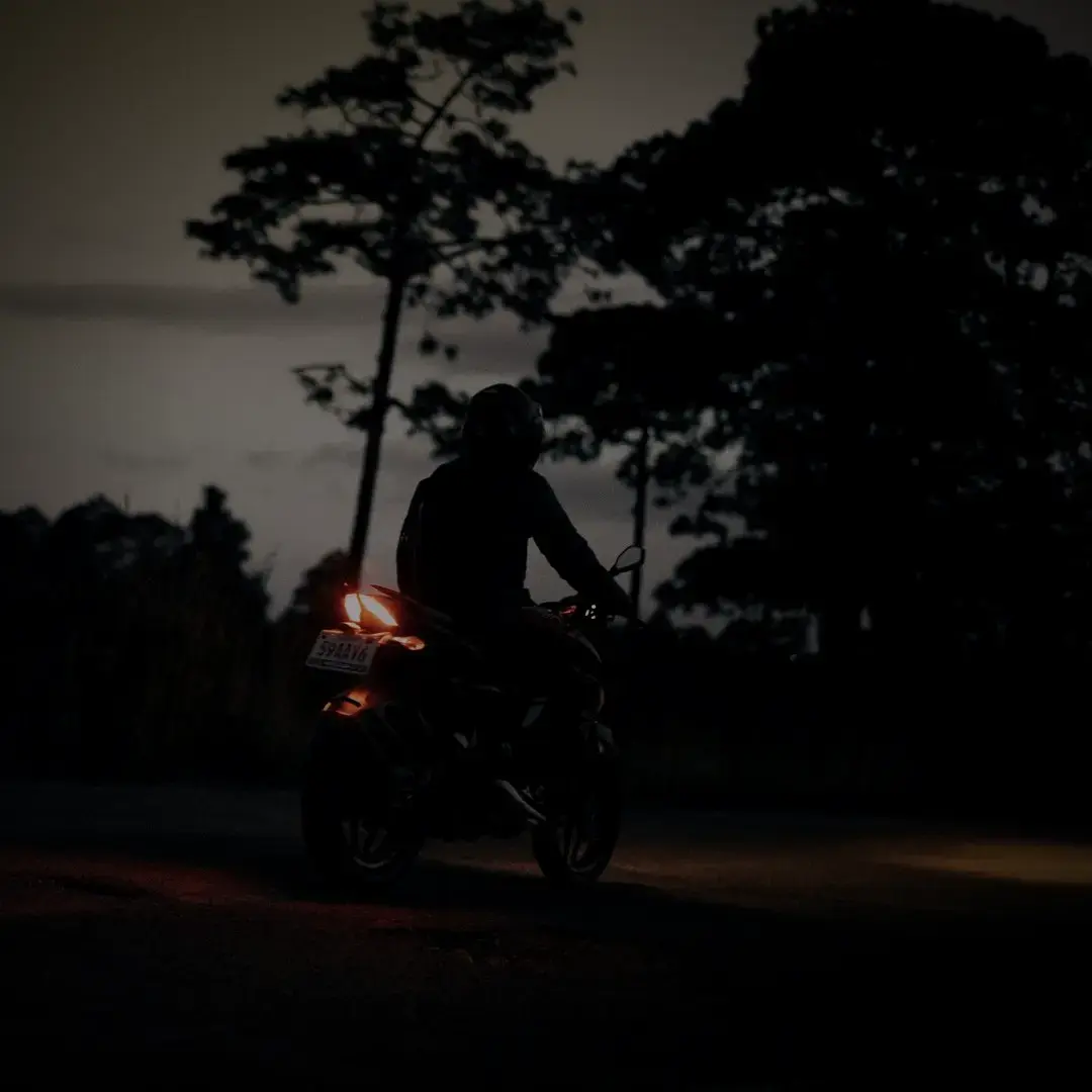 A motorcyclist on an empty road at dusk — a Raksi Hour late-night delivery run in Kathmandu.