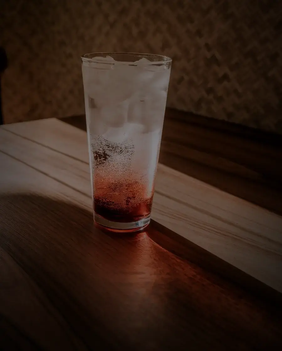 A clear iced drink on a cafe table at night — 8848 Vodka, delivered across Kathmandu Valley by Raksi Hour.