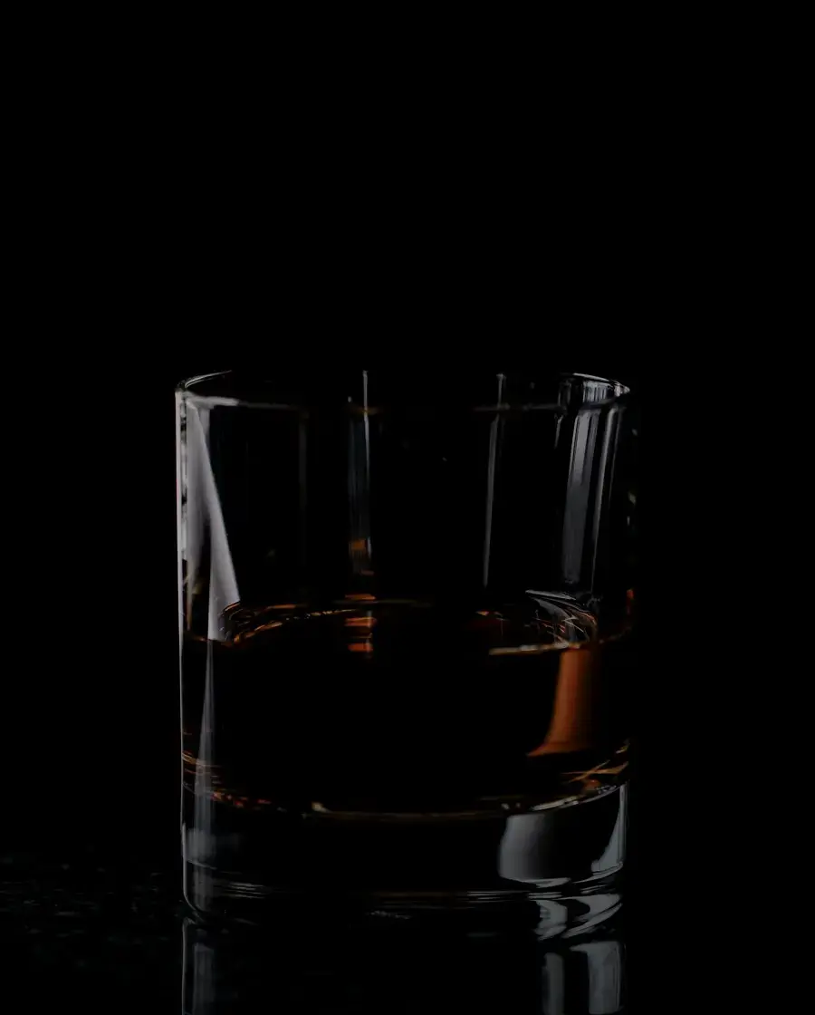 A tumbler of whisky on a dark table — Old Durbar, delivered across Kathmandu Valley by Raksi Hour.
