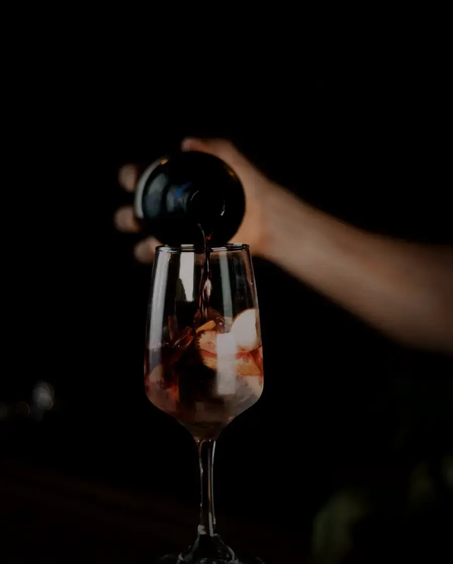 Red wine being poured into a glass in a dark room — Big Master Red Wine, delivered across Kathmandu Valley by Raksi Hour.